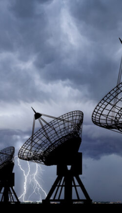 Three Communication Satellite dishes at thundershtorm .